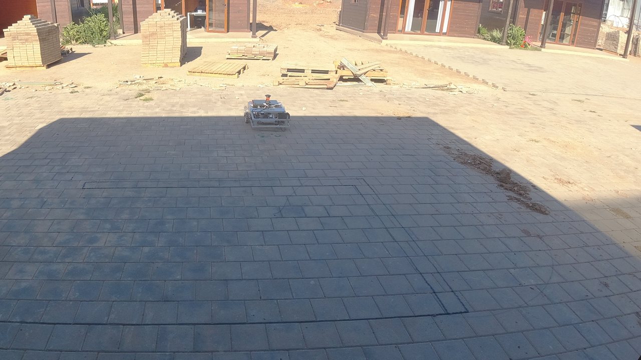 The COROSOLS robot on a real pilot site, with freshly traced layout lines on the paved floor.
